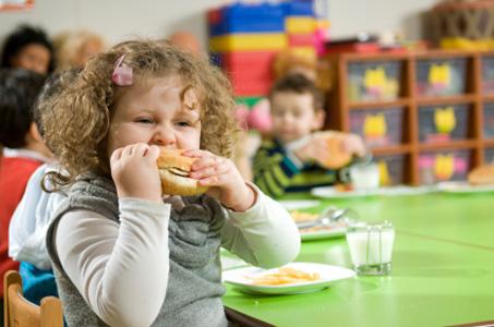 bambina sovrappeso Una bambina sovrappeso mangia un panino