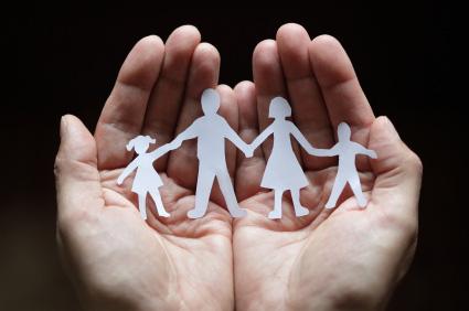 mani che racchiudono la sagoma di una famiglia