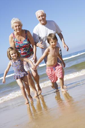 nonni nipoti corrono sulla spiaggia estate