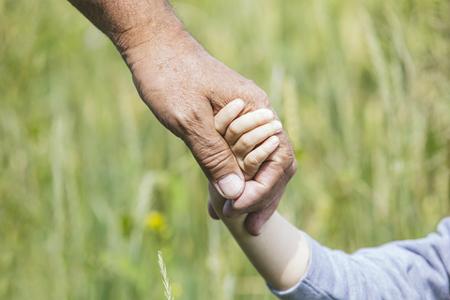 nonno stringe la mano del nipote