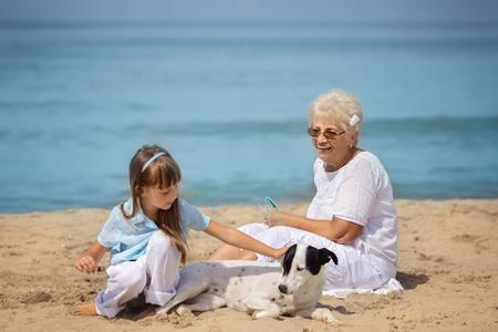 nonna nipote al mare in spiaggia con cane