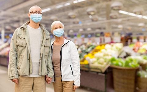 coppia persone anziane con la mascherina al supermercato